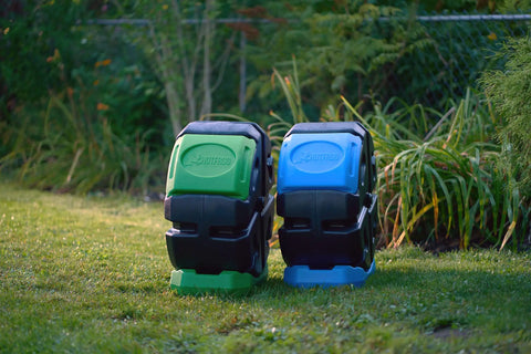 Two HotFrog Half Size Rolling Single Chamber Tumbling Composters on grass, black with green and blue panels, 19 gallon capacity