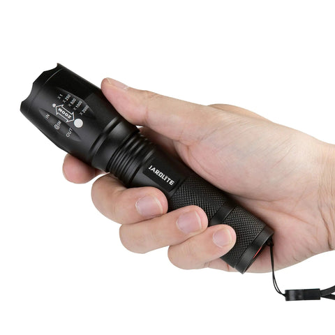 Handheld view of a Powerful Emergency LED Handheld Flashlight Set 4 Pack With Adjustable Focus in a person's hand, black build