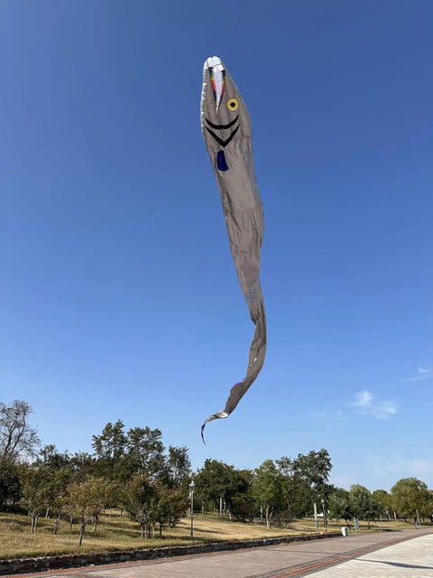 Massive 61ft Silver Soft Parafoil Beltfish Kite with Reel flying in clear blue sky, eye-catching sea monster design.