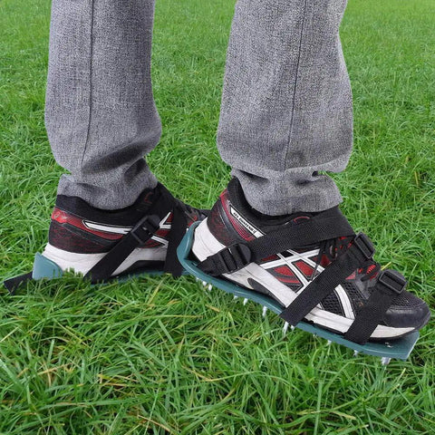 Person wearing Lawn Aerator Sandals Spiked Shoes For Yard Work on grass, showing 3 straps and iron spikes.