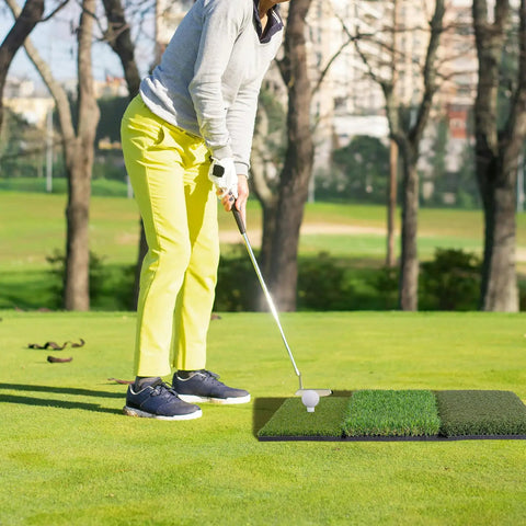Person practicing golf on Tri Turf Golf Hitting Mat 24 By 24 Inch Portable Practice Mat for indoor and outdoor use with realistic 3 turf surfaces.