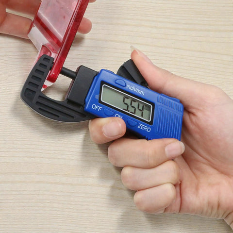 Digital Thickness Gauge Micrometer With Portable Rugged Build And Quick Inch Metric Switching used to measure a red plastic item.