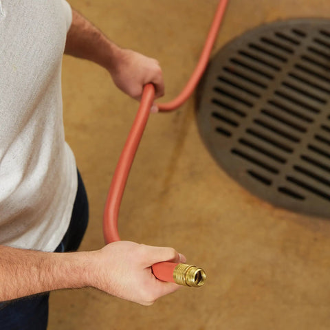 Man holding Heavy Duty Three Quarter Inch By Seventy Five Foot Garden Hose With Kink-Resistant, Commercial Grade Rubber And Vinyl Construction