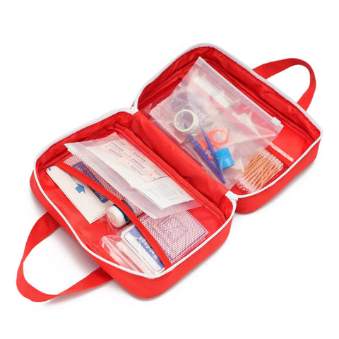 Open red compact first aid kit bag with visible compartments and medical supplies, featuring dual handles for grab and go use.