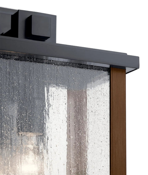 Close-up of Outdoor Wall Light Sconce In A Sleek Dope Black Finish With Clear Seeded Glass detail, traditional rustic style, exterior lighting.