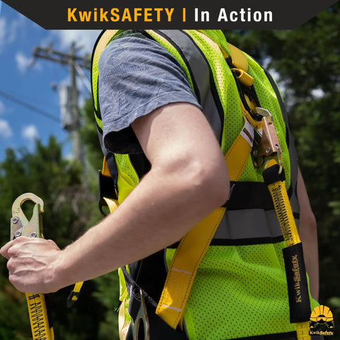 Worker wearing Typhoon Full Body Safety Harness With Cushioned Back And Shoulder Support Three Heavy Duty D Rings For Fall Protection ANSI OSHA Construction Roofing Tower Climbing Scissor Lift Worksite Ready, holding safety hook.