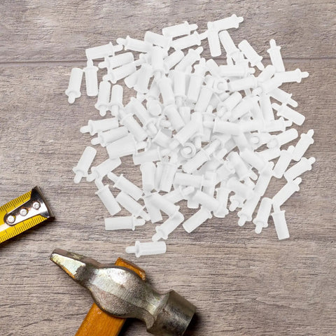 White Shutter Repair Pins, 120 Piece Movable Louver Fasteners scattered on a wooden surface next to a hammer and measuring tape.