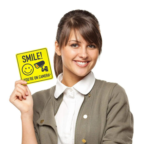 Smile Youre On Camera Signs 7 By 7 Inch 8 Pack Security Notice Stickers For Home Office And Outdoors Deterrent Alerts Visitors Theyre On Camera And Helps Keep Your Family And Property Safe With This Easy To Install Sign Set. 7x7 vinyl sign held by woman