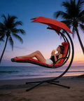 Woman relaxing on Freestanding Arc Stand Hanging Chaise Lounge Swing Chair With Curved Steel Frame on beach at sunset.