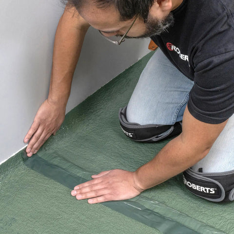 Installation of Real Deal 3 In 1 Flooring Underlayment Roll For Laminate And Engineered Wood smoothing edges against a wall.