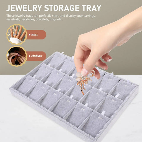 Hand placing a decorative earring in the Super Smooth Large 18 Compartment Velvet Jewelry Storage Tray With Handy Necklace And Watch Display Pad Totally Organized For Craft Sessions And Stylish Desk Vibes.