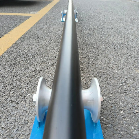 Beefy Heavy Duty Cable Puller Sheave for Large Scale Laying showing pipeline sliding over aluminum U-groove base on pavement