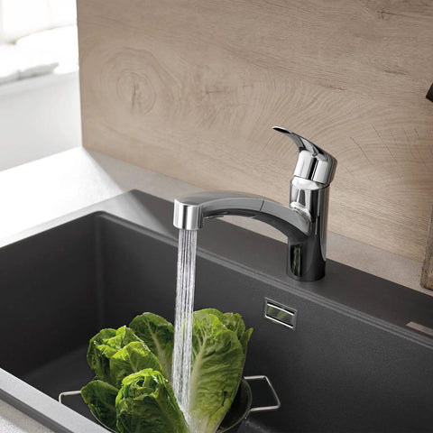 Eurosmart Dual Spray Pull Out Kitchen Faucet With Sprayer 1.75 GPM in use over a dark sink with lettuce, chrome finish visible