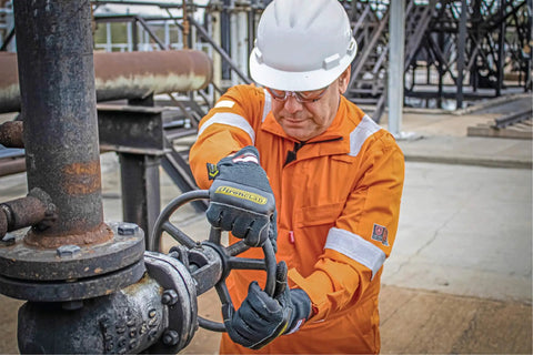 Worker using Heat Worx Heavy Duty FR Fire Resistant Gloves For Handling Hot Stuff Up To 600°F, NFPA 2112 Certified, in industrial setting.