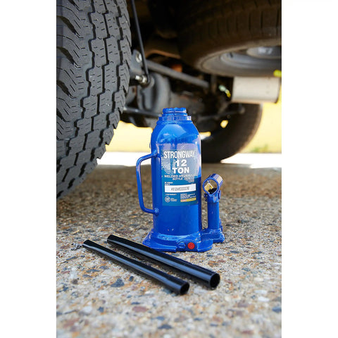 Badass 12 Ton Hydraulic Bottle Jack With High Grade Steel Welded Base For No Sweat Shop Grind Daily Auto Repair And Farm Hauling 15.94 To 18 Inch Lift Height Built Legit next to vehicle tire on gravel.