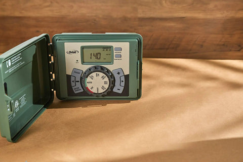 Easy Set Logic 12 Zone Outdoor Sprinkler Timer with Locking Cabinet for Indoor Outdoor Installations showing digital display and dial.
