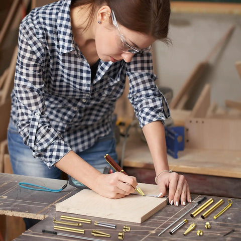 Person using Ten Slimline Pen Kit Sets For Wood Turning With Dope Gold Finish Refill Ready Lathe Tools on wooden board