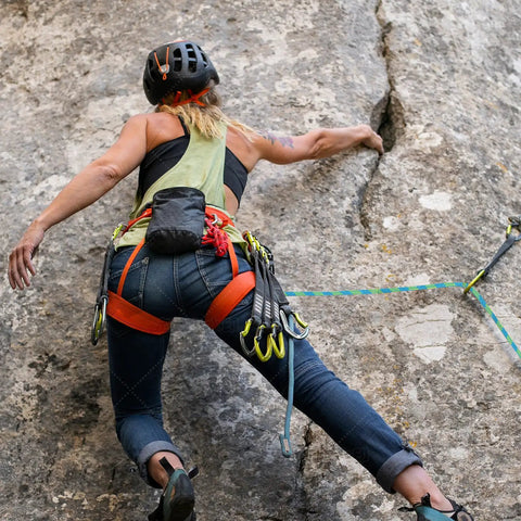 Climber using Half Inch By Hundred Feet Arborist Tree Climbing Rope Forty Eight Strand Polyester Static Bull Line on rock face.
