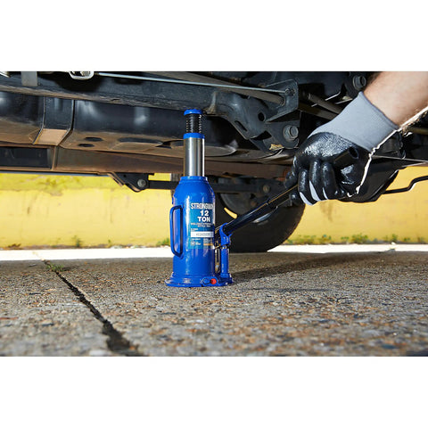 Badass 12 Ton Hydraulic Bottle Jack With High Grade Steel Welded Base lifting under a vehicle, showing 15.94 to 18 inch lift height.