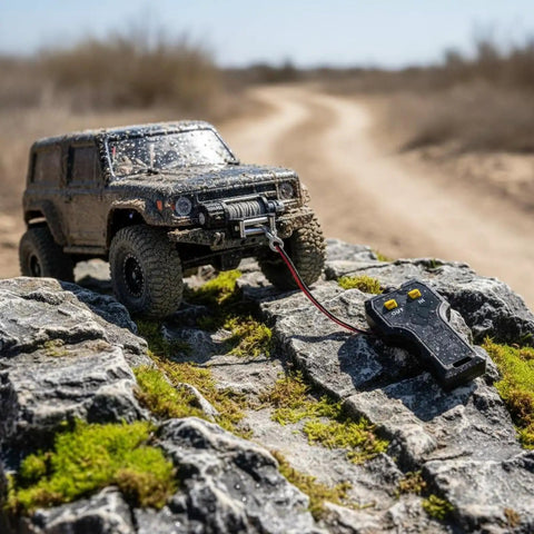 Powerful Electric Winch With Smart Rc Controller For Trail Crawlers positioned on rugged rocks with a detailed RC vehicle nearby.