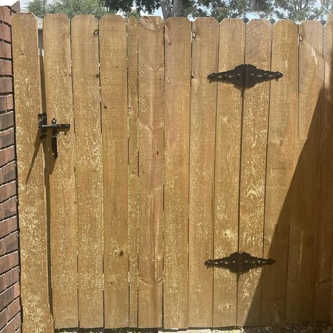 Heavy Duty Eight Inch Fence Gate Hinges With Matte Black Steel Finish for Outdoor Wood Fences and Sheds on a wooden gate.