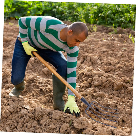 Person using Five Pronged Iron Manure Fork For Farming And Gardening, Heavy Duty Rake For Quick Lawn Cleanup And Manure Removal