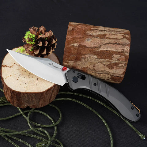 Premium Folding Pocket Knife With Top Shelf Dc53 Steel Blade And Rock Solid Aluminum Handle Loaded With A Slim Deep Carry Clip for camping and hiking, resting on a wood log.