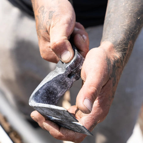 Close-up of Heavy Duty Indexing Crowbar And Nail Puller Wrecker Tool in hand, showing steel claw for demolition tasks.