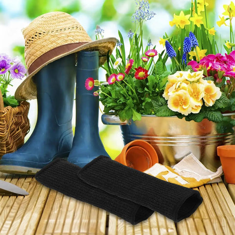 Solid Cut Resistant Arm Sleeves Two Pack Black Elastic Forearm Guards For Yard Work Welding And Mechanics Thorn Proof Armor on wooden table with gardening accessories.