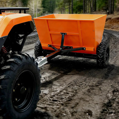 71 Gallon Tow Behind Sand And Salt Spreader For Snow And Ice Control, bright orange ATV attachment on dirt trail.