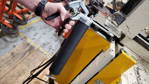 Person using Standard Duty Pistol Grip Grease Gun With Textured Barrel And Rubberized Grip For Easy, No-Fuss Handling indoors