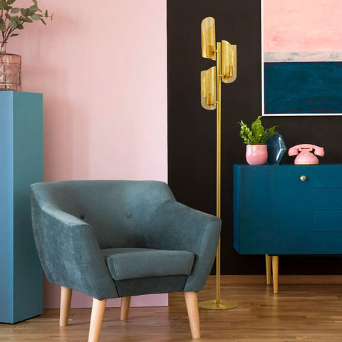 LED Tree Floor Lamp With 3 Light Heads In Brass Finish, Metal Cage Shade next to a blue armchair in a modern living room setting