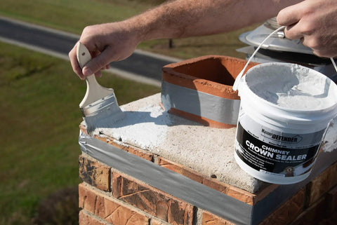 Applying Bone Dry Chimney Crown Sealer Brushable Elastomeric Waterproof Membrane on chimney top with a brush.