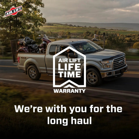 Truck with motorcycles on a highway, showcasing Heavy Duty Air Spring Kit For Ram 1500 2019 Through 2024 with lifetime warranty.