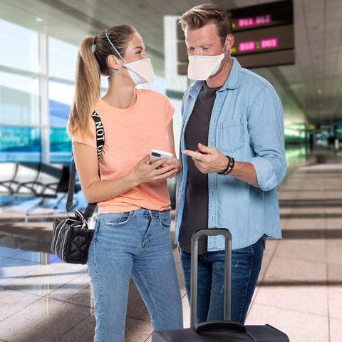 Two travelers wearing N95 Particulate Respirator Mask With Headband, Fluidshield Design, breathable comfort, in an airport.