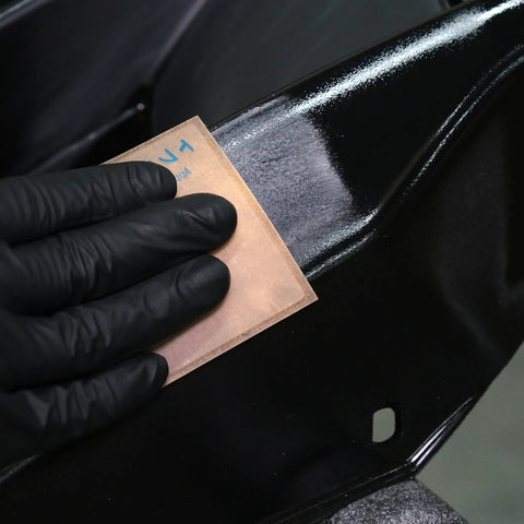 Using PSA sanding sheet from Starter Kit With PSA Sanding Sheets For Nibs Runs And Imperfections SP9737 K800 K3000 on black surface