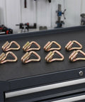 Heavy Duty Steel Ratchet Tie Down Hooks For 25mm Straps, Zinc Plated With Anti Slip Surface, 8 Pack arranged on tool drawer