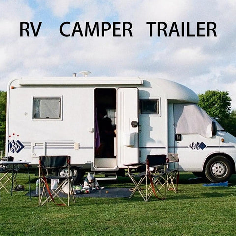 White RV camper trailer parked on grass with chairs outside, showcasing outdoor travel lifestyle.