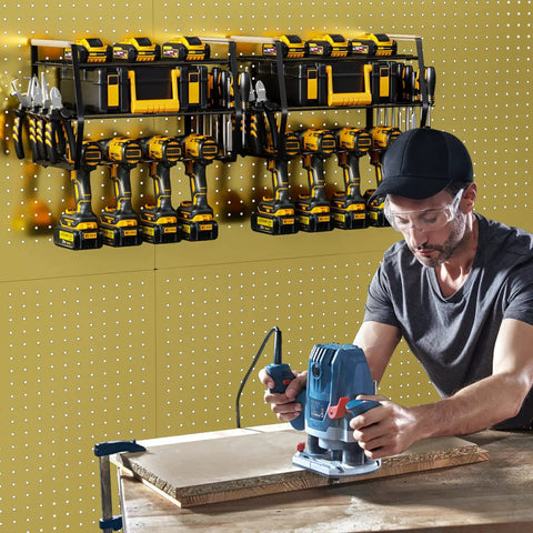 Man using a tool with a Power Tool Organizer Wall Mount For Garage Storage holding drills and tools on a pegboard wall.