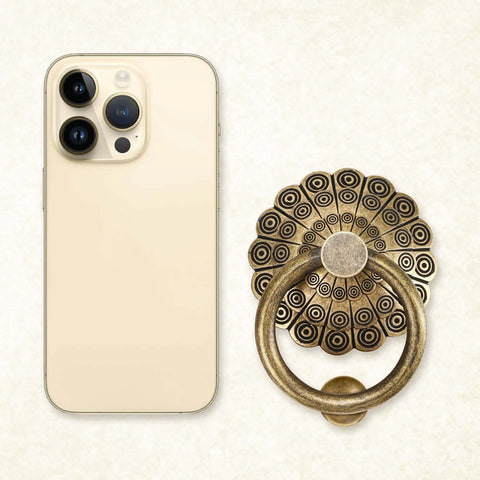 Antique Door Knocker With Bronze Brass Ring Pull next to modern smartphone for size comparison