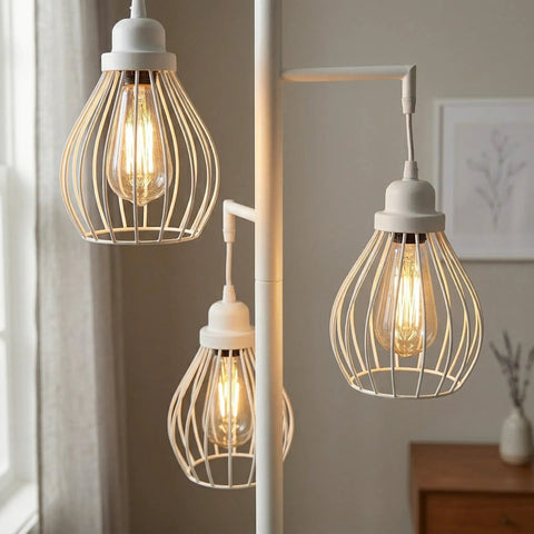 Close-up of Teardrop Modern LED Floor Lamp with three cage shades and warm Edison bulbs in a bedroom setting.