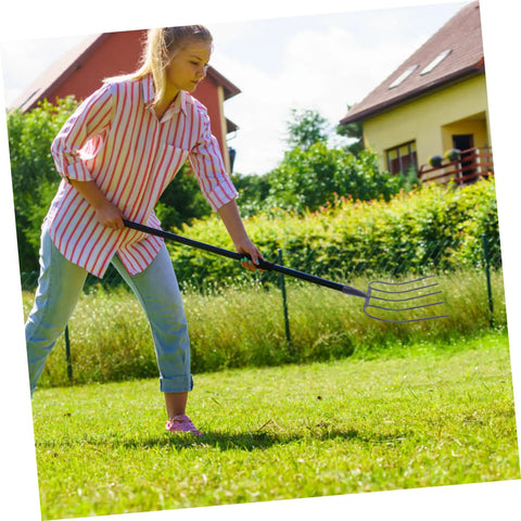 Woman using Heavy Duty Manure Fork For Farming And Gardening, Iron Pitch Fork Built Tough As Nails on green lawn