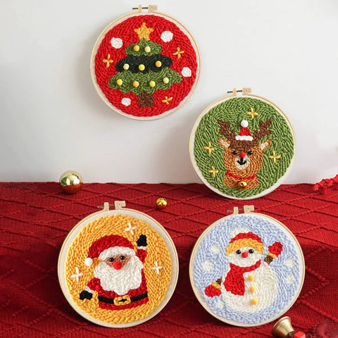 All In One Punch Needle Kit With Wooden Handle Embroidery Tools Hoops Cloth Scissors Threaders And More Ideal For Beginners To DIY Crafts Home Decor And Gifts In Pink featuring four Christmas-themed punch needle designs in embroidery hoops.