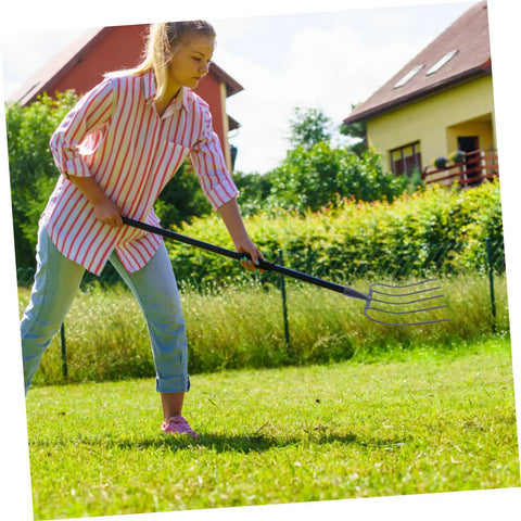Person using Heavy Duty Iron Manure Fork Pitch Fork For Lawn Maintenance And Rural Use on grass