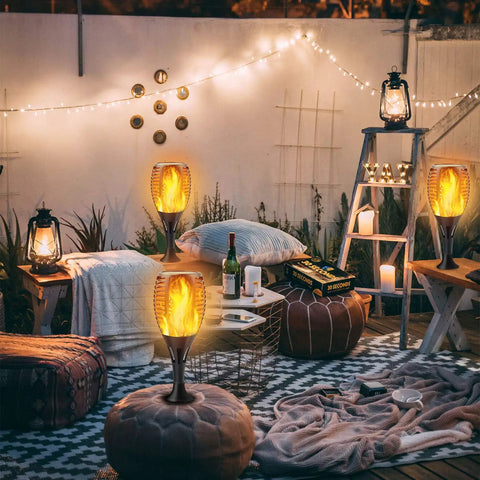 Outdoor evening setup with Lit Upgraded Solar Flame Lights, blankets, cushions, and fairy lights creating a cozy atmosphere.