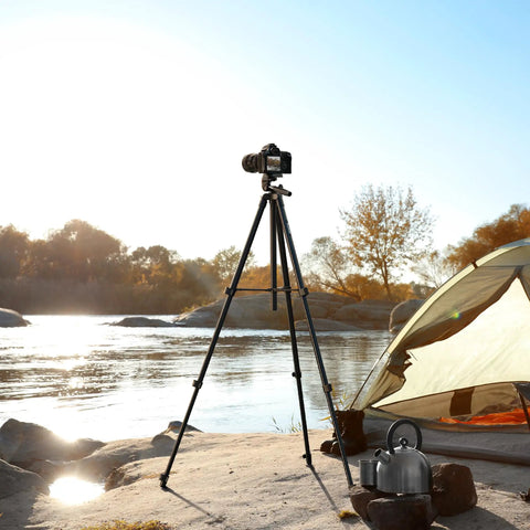 60 Inch Lightweight Travel Camera Tripod For Canon And Nikon DSLRs by a riverside with a tent and kettle, black sturdy alloy