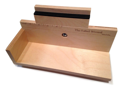 Heavy Duty Manual Bottle Labeler for Wine Beer and Jars with engraved measurement guide and sturdy wooden design.