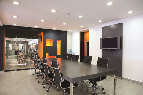 Modern conference room with 4 Inch LED Gimbal Recessed Downlight 500 Lumen, 90 CRI, 3000K, Matte White lighting installed.