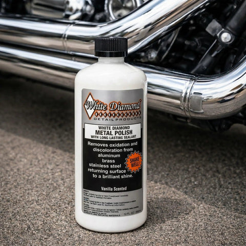 Bottle of Metal Polish With Long Lasting Sealant Cleaner Polisher Protectant All In One beside motorcycle chrome pipes
