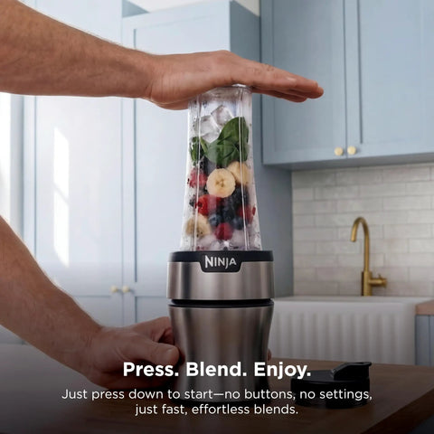 Heavy Duty Personal Blender Featuring 900W Push To Blend Motor And Pro Extractor Blades Crushing Ice For Nutrient Dense Smoothies Including Three Grab And Go 20 Oz Serveware Cups In Classic Silver with fruits and spinach ready for blending.